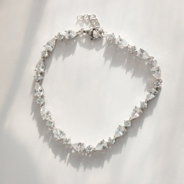 Silver bracelet with clear gemstones on a white background