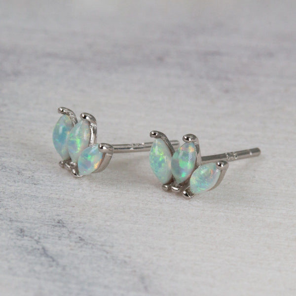 Pair of opal stud earrings on a marble background